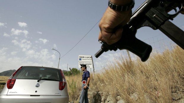 Organised crime is a problem in southern Italy. An Italian police officer holds a sub-machine gun at a roadblock in Calabria.