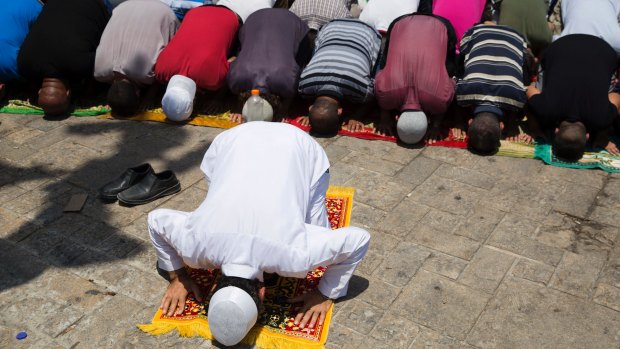 Palestinians pray outside the Lion's Gate near the Al Aqsa Mosque compound.