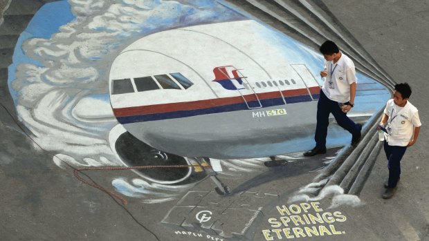 Students walk past a mural featuring Malaysia Airlines flight MH370 at a school in Manila.