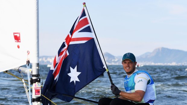 Tom Burton celebrates winning the gold medal in the Men's Laser class. This year he didn't have to cover up the Zhik logo on his arm because they were official sponsors.