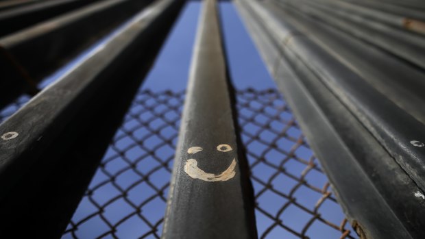 Graffitti adorns metal bars marking the United States border where it meets the Pacific Ocean in Tijuana, Mexico.
