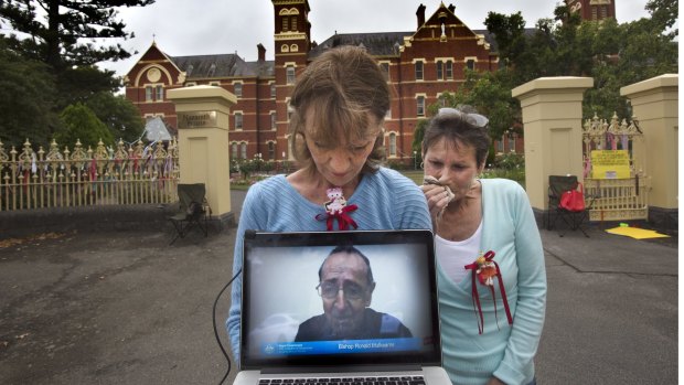 Gabrielle Short and Wendy Dyckhoff watch the live stream of Bishop Ronald Mulkearns testimony at the royal commission.