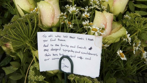 A message is seen on a floral tribute left at a memorial set up near the crash site.