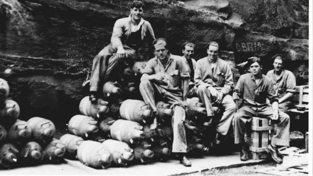 RAAF armourers sitting on a pile of mustard gas canisters in Glenbrook in 1944.