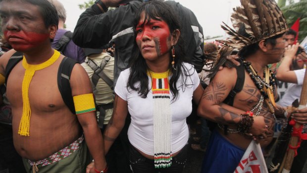Indigenous protesters hold hands near an entrance way to the Rio20 conference in protest over the Belo Monte dam construction.