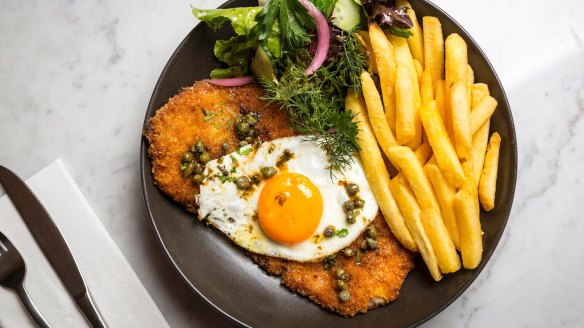 Pork schnitzel with chips, fried egg and capers.