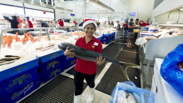 Lizzie Hilario helps as customers at Fyshwick FishCo Market to stock up on seafood for Christmas.