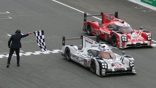 All night long: The Porsche 919 Hybrid driven by Nico Hulkenberg crosses the Le Mans finish line. 