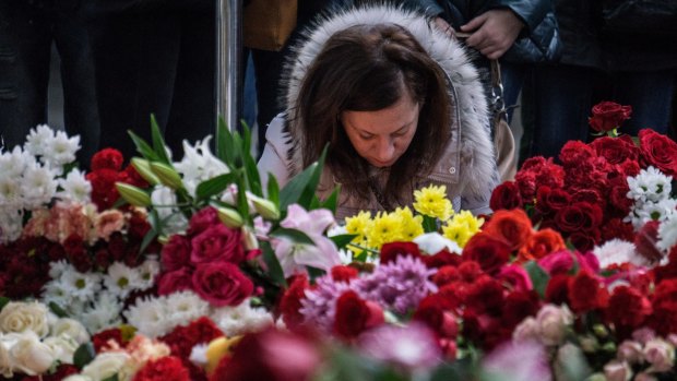 A woman at Pulkovo Airport in St Petersburg, Russia lights a candle in memory of the victims of the Airbus A321 crash.