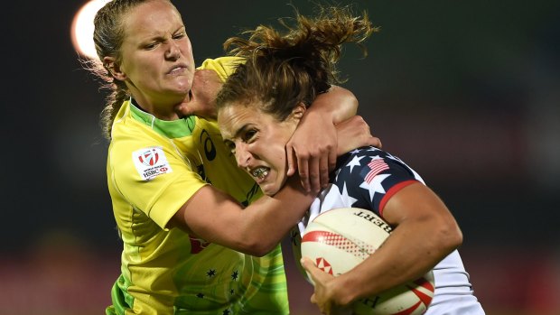 Crash tackle: Emma Sykes (left) brings down Ryan Carlyle of the US in Dubai.