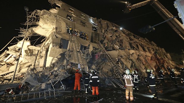 Rescue workers search a toppled building in Tainan.