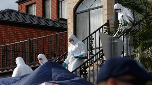 Investigators leave the Greenvale home where a teenager was arrested on Friday.