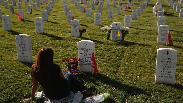 Dead remembered: Aileen Lucas visits the grave of her husband, US Marine Corps Major Christopher Lucas, on Veterans Day in Section 60. 