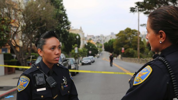 San Francisco Police Officer Grace Gatpandan speaks with another officer as they respond to reports of a shooting at Dolores Park in San Francisco.