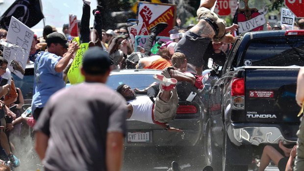 A vehicle drives into a group of protesters demonstrating against a white nationalist rally in Charlottesville, Virginia. Rebel Media's coverage of event drew fire and triggered a wave of condemnation. 