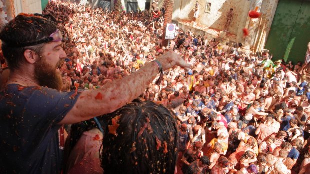 Revelers throw tomatoes from a balcony during the annual  tomato fight fiesta in Bunol on Wednesday.