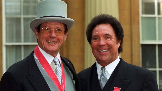 Roger Moore, CBE (left) and Welsh singer Tom Jones, OBE at Buckingham Palace after receiving their honours from the Queen. 