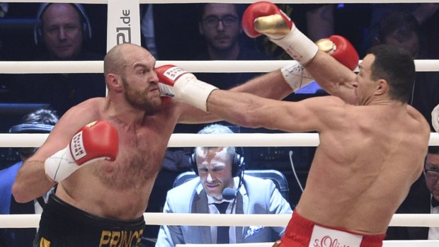 Battle of the big men: Ukraine's Wladimir Klitschko, right, and Britain's Tyson Fury exchange blows in their world heavyweight title fight for Klitschko's WBA, IBF, WBO and IBO belts in the Esprit Arena in Duesseldorf, Germany.