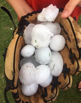 Resident Stacey Valdez shows hail stones produced by the storm in Sayre, Oklahoma.