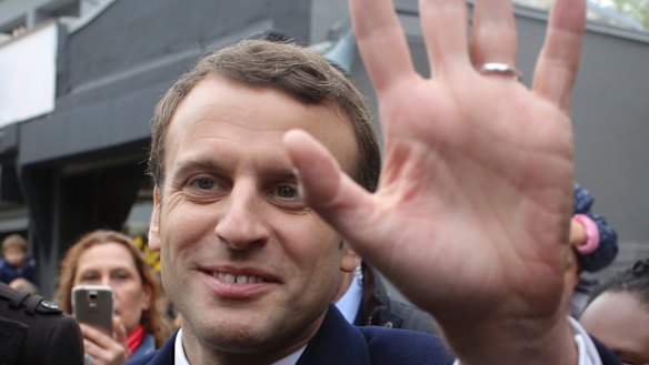 Centrist candidate Emmanuel Macron waves to supporters.