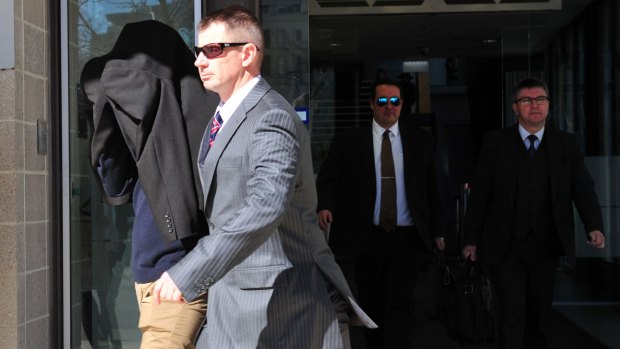 Under guard: Harlan Agresti is escorted from the ACT Magistrates Court.