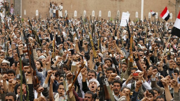 Houthi rebels hold up their weapons in the Yemeni capital, Sanaa.