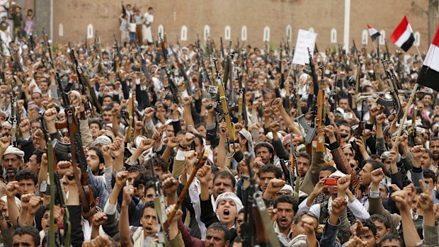 Houthi rebels hold up their weapons in the Yemeni capital, Sanaa.