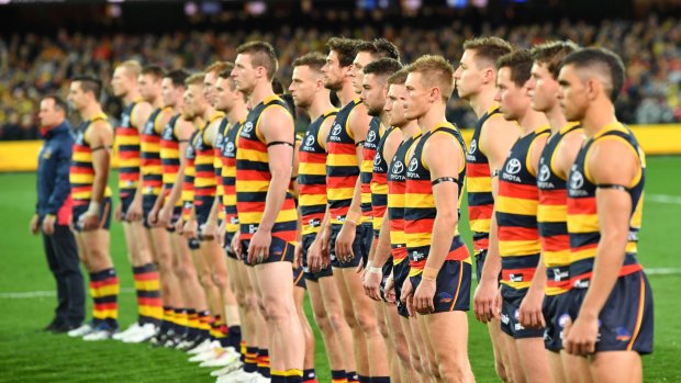 The Crows stand for the national anthem before the win over GWS. 