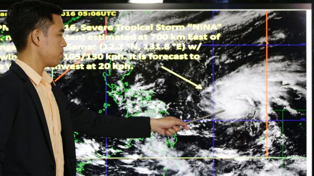 Weather specialist Benison Estareja shows the track of Tropical Storm Nock-Ten.