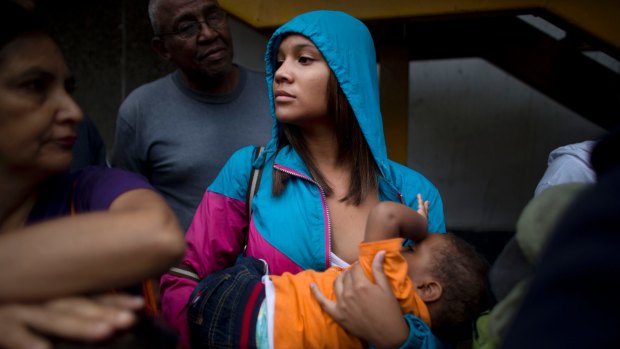 Madeley Vasquez, 16, breastfeeds her one-year-old son Joangel as she waits in line to buy food in Caracas, Venezuela.