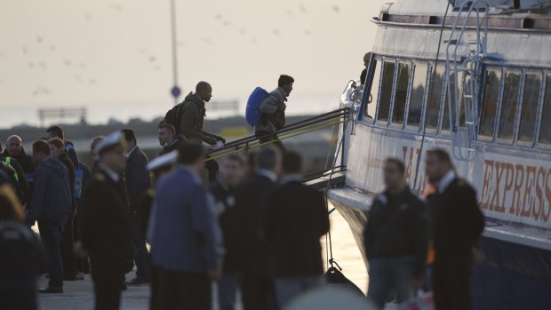 Migrants get on a ferry at the port of Mytilini in the Greek island of Lesbos, on Monday, during the first day of the implementation of the deal between EU and Turkey. 