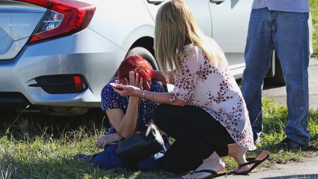A woman consoles another as parents wait for news regarding a shooting at Marjory Stoneman Douglas High School in Parkland, Florida, on Wednesday.