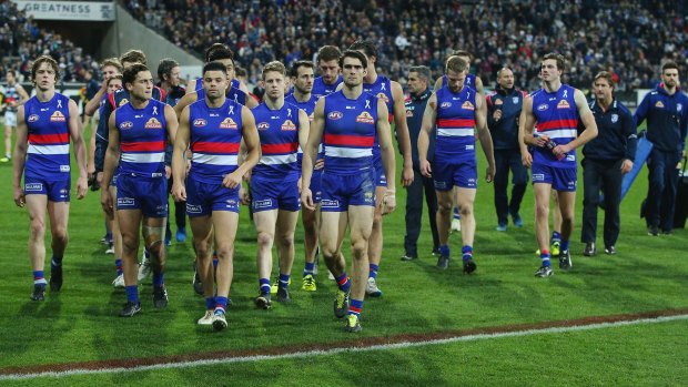 The dejected Bulldogs leave the ground after the loss to Geelong.
