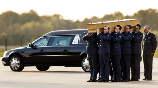 Dutch military men carry a coffin containing the remains of a victim of flight MH17.