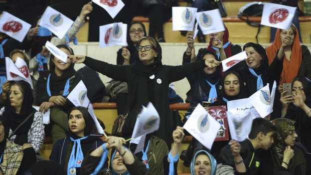 Iranian women wave flags of reformists for the parliamentary elections in a campaign rally in Tehran on Thursday.