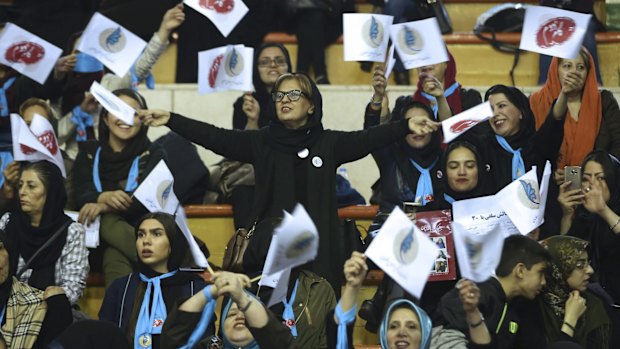 Iranian women wave flags of reformists for the parliamentary elections in a campaign rally in Tehran on Thursday.