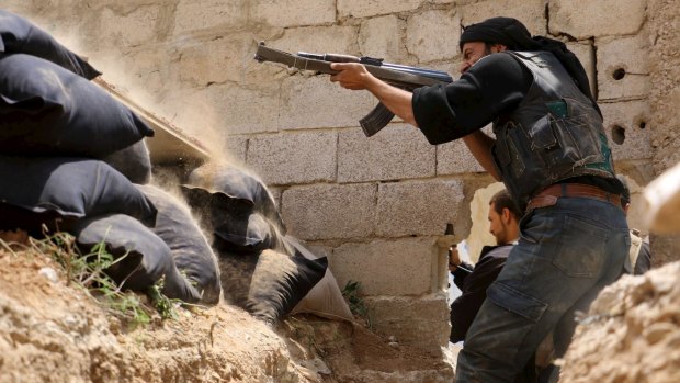A Jaysh al-Islam (Army of Islam) rebel fighter shoots at  forces loyal to Syria's President Bashar Al-Assad on Sunday.