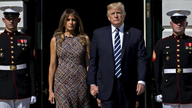 US President Donald Trump and first lady Melania Trump walk out of the White House to participate in a moment of silence for victims of the Las Vegas mass shooting.