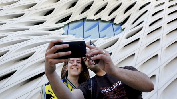 Pedro Cadima takes a selfie of himself and his wife Eva in front of the Broad Museum's "oculus" window in Los Angeles.