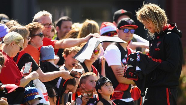The Bombers' Dyson Heppell signs autographs during an Essendon training session on Tuesday.