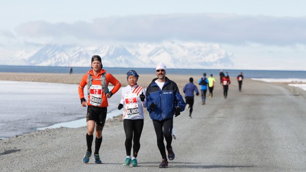 Eline Oidvin runs the 2017 Spitsbergen Marathon in Norway between Hakon Fram Stokka, left, Andrew W. Lehren.