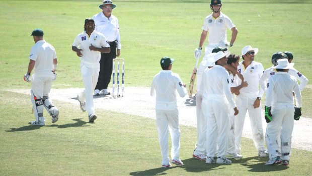 Yasir Shah is congratulated by teammates after bowling Australian danger-man David Warner.