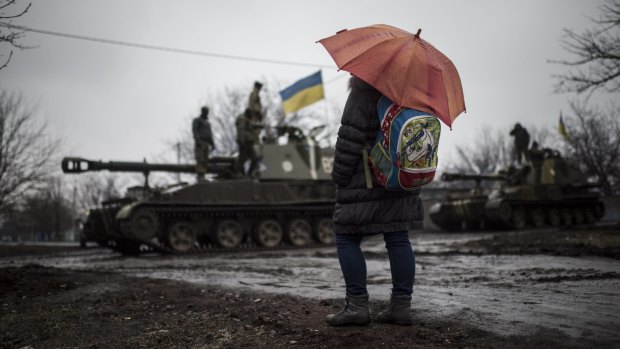 A schoolgirl watches Ukrainian armoured vehicles on the outskirts of Donetsk, in Ukraine, on Wednesday.