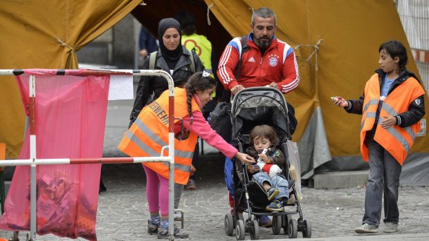 A refugee family is given candy as they arrive at Munich Hauptbahnhof railway station.