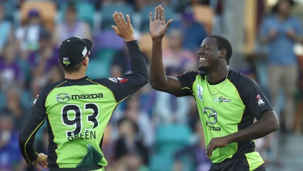 Settling in: Carlos Brathwaite high-fives new teammate Chris Green after taking a wicket.