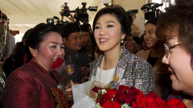 Thailand's former prime minister, Yingluck Shinawatra, centre, is given flowers by her supporters just before her impeachment in January.