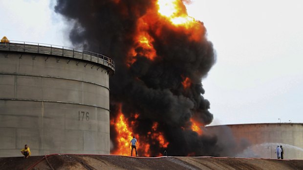 Firefighters work at the storage tanks of an oil refinery following rocket attacks by Shiite rebels, known as Houthis, in the port city of Aden.