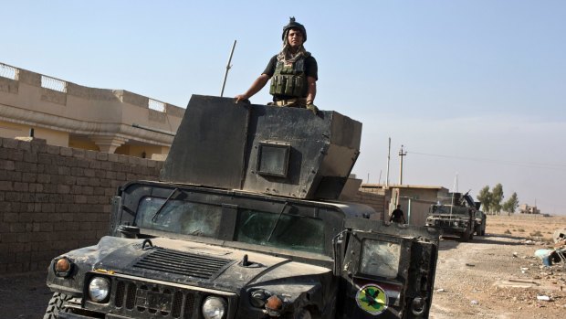 An Iraqi special forces soldier stands atop a Humvee in the village of Bazwaya, eight kilometers from the centre of Mosul.