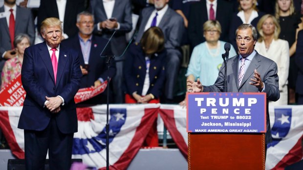 Two angry white men: Donald Trump listens to Nigel Farage, ex-leader of the British UKIP party in Jackson, Mississippi last week. 