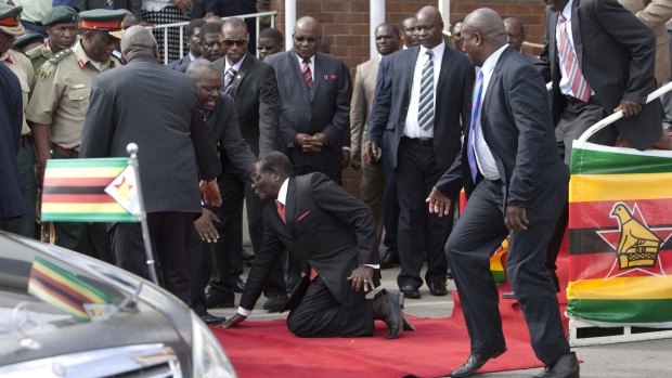 Going: Mugabe on his knees.